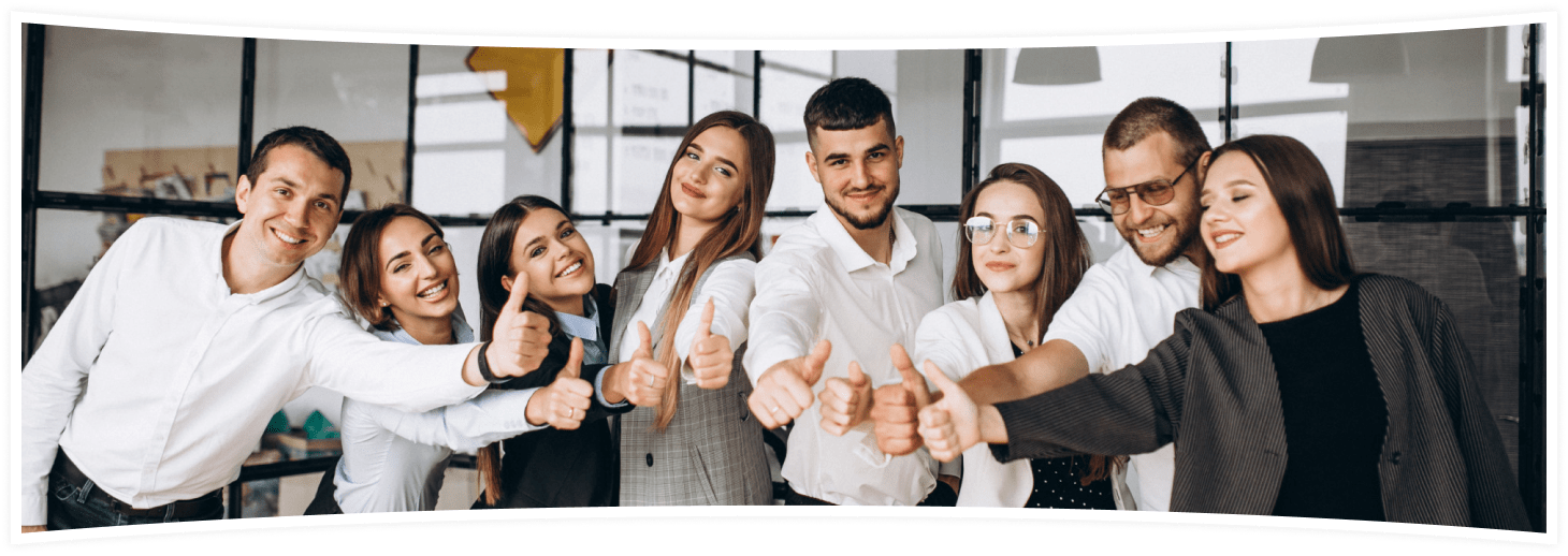 A group of eight smiling people, standing indoors, happily giving thumbs-up gestures. They are dressed in business casual attire, suggesting a positive and enthusiastic office environment. The background features a modern office space with glass walls.