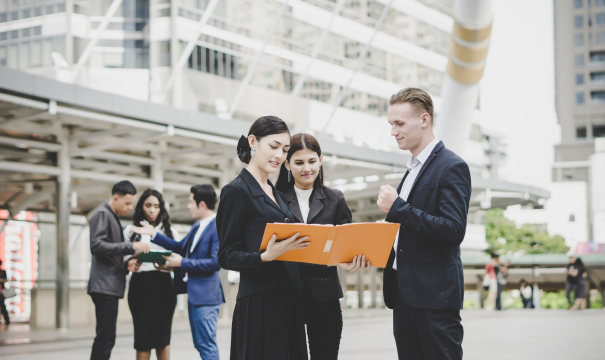 Businesspeople collaborating over a document. 