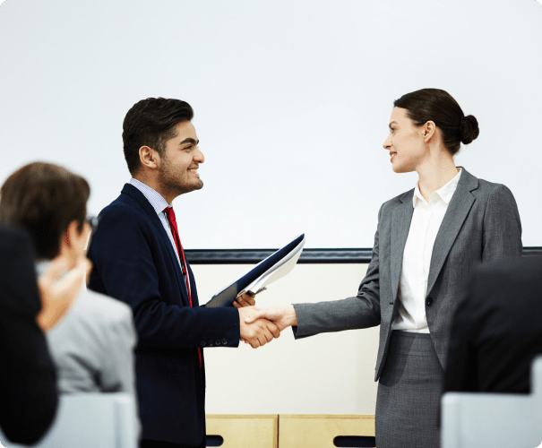 Man and woman in business attire shaking hands.