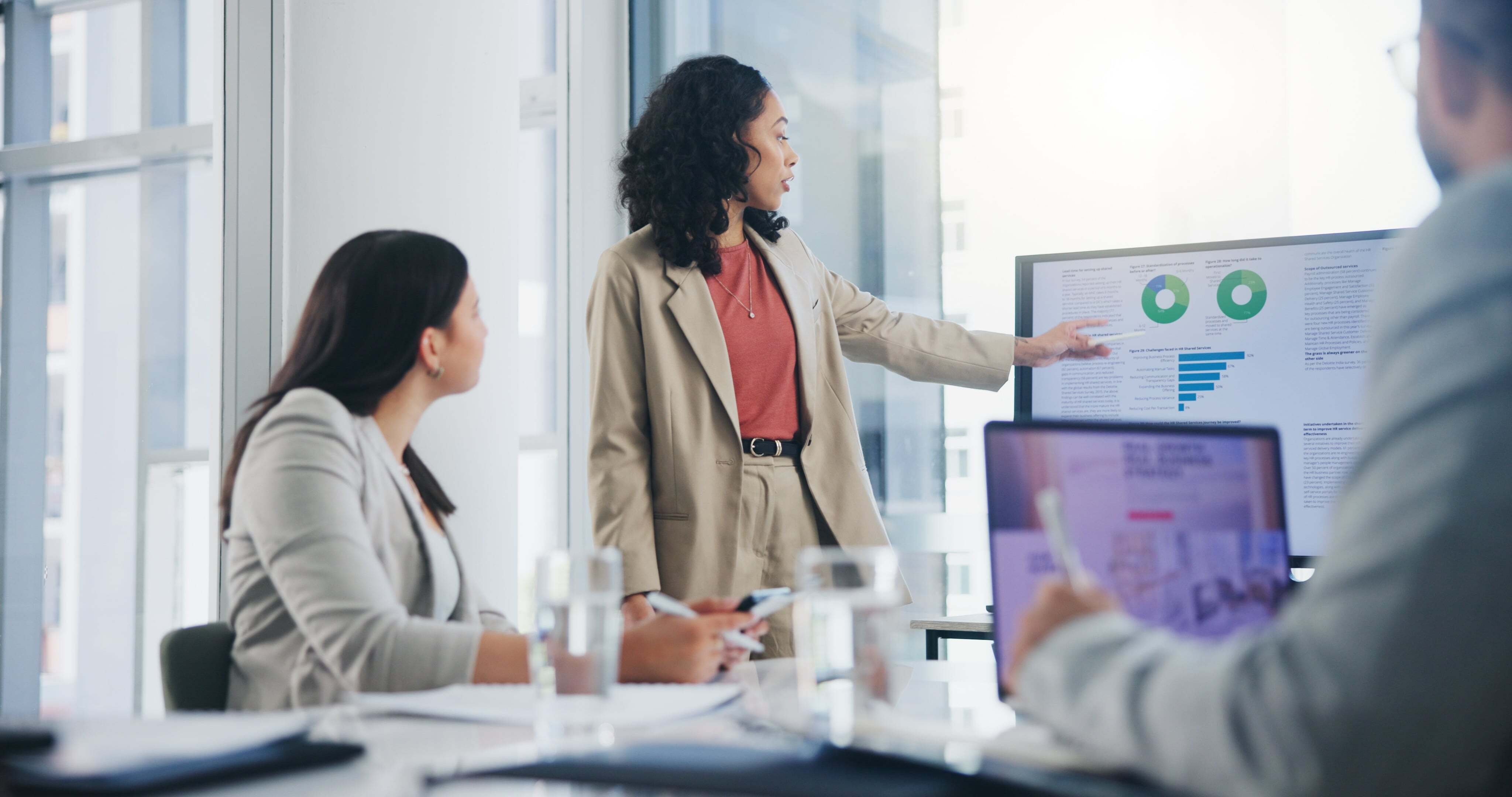 Businesswoman presenting sales data during a team meeting, discussing CRM integration and strategies to improve sales efficiency through data-driven insights and collaboration.